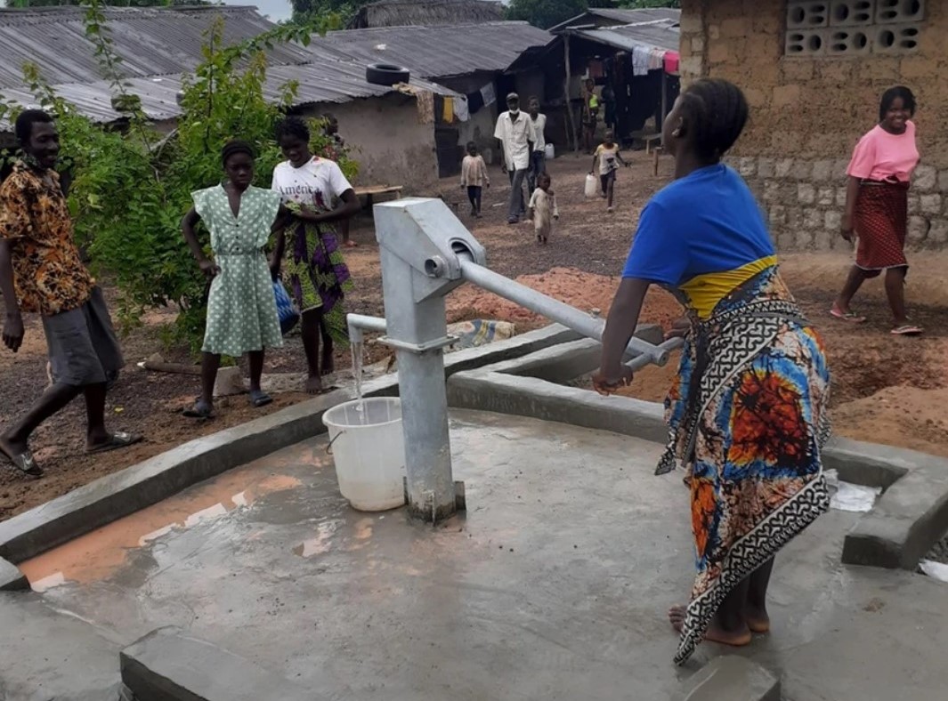 Woman using a hand pump in Liberia